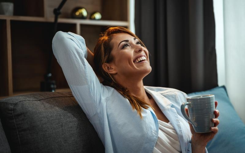 a woman laughing while holding a cup