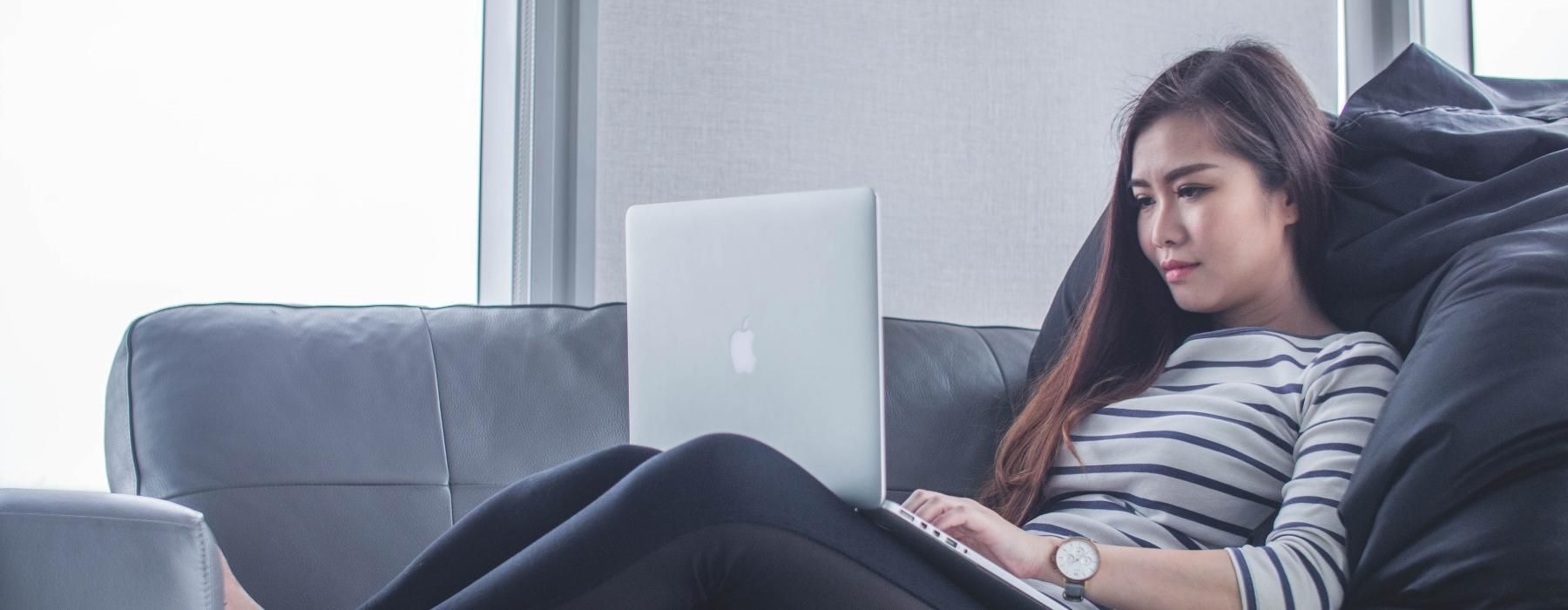 a person sitting on a couch with a laptop
