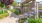 a fenced pool area with lush landscaping